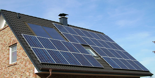 Telhado residencial que utiliza diferentes tipos de energia solar: as placas fotovoltaicas e a claraboias para iluminaçãonatural